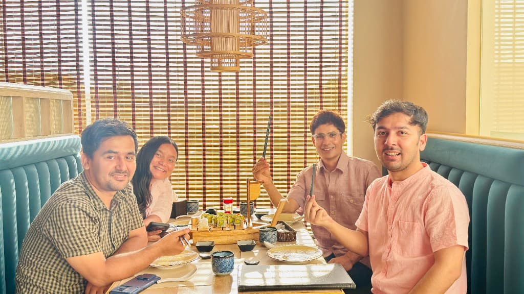 Prem Sapkota dining and laughing with friends over a shared meal